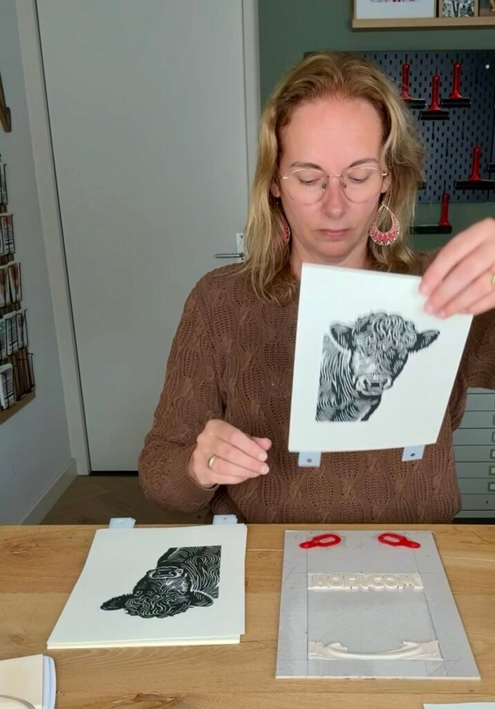 Angela Kuiper demonstrating her mounting board with Ternes Burton registration pins for linocut printing.